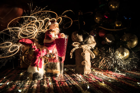 Red wine in crystal glass with bottle on colorful carpet with creative New Year artwork decorations. Copy space