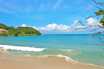 Bright vacation beach  with coastal scenery and a wave crashing shore