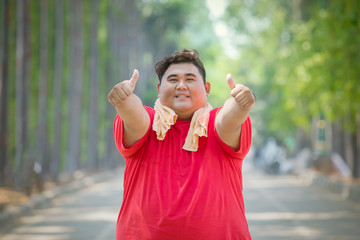 Portrait of fat Asian man doing thumbs up pose