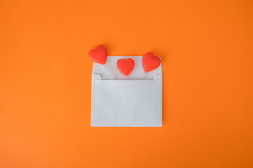 Top view of an envelope and orange love candies