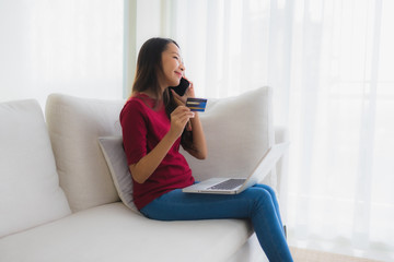 Portrait beautiful young asian women using computer laptop with mobile phone and credit card