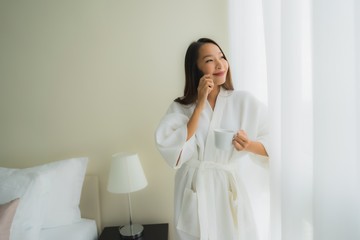 Portrait beautiful young asian women with coffee cup and mobile phone on bed