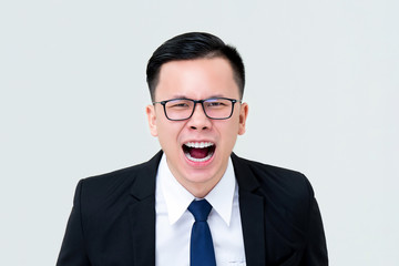 Angry Asian businessman screaming isolated on gray background