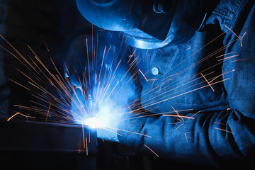 factory welder welds parts with a semi-automatic welding machine