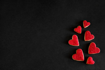 Red heart shaped cookies, symbol of love on black background with copy space