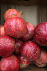 harvest ripe juicy pomegranates in a cardboard box in the store