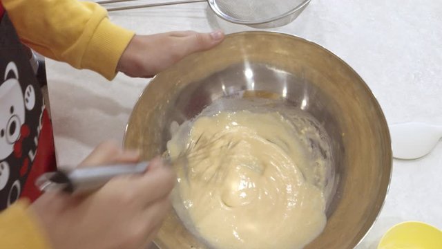 Whicking cake batter by hand in a mixing bowl