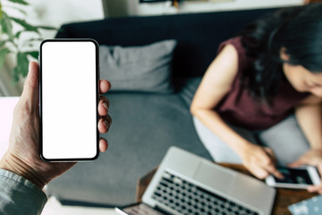 Mockup image blank white screen cell phone.man hand holding texting using mobile on desk at home office.background empty space for advertise text.people contact marketing business,technology 