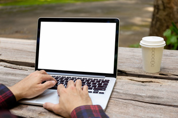 Fototapeta premium mockup image blank screen computer with blank white background for advertising text,hand man using laptop contact business search information on desk at home office.marketing and creative design