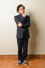 Full body shot of Japanese businessman in suit thinking