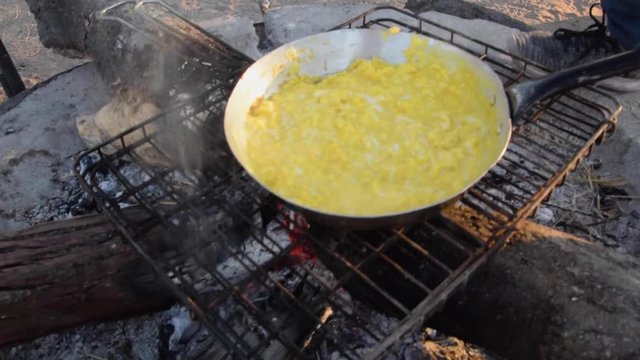 Making scrumbled eggs on campfire at campsite in Central Kalahari Game Reserve. Botswana.
