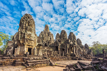 Bayon temple with cloud, blue sky and tourist in Angkor wat Angkor thom area, Siem reap of Cambodia. Prasat Bayon most  smiling stone faces on the many towers.