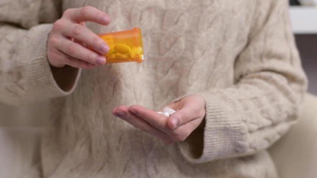 Woman takes vitamins. Woman pours pills into the palm