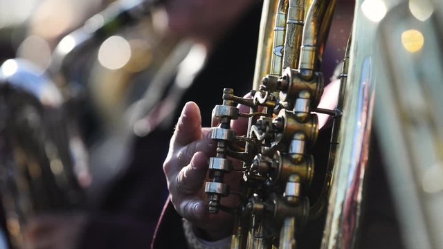 Detail footage depicting a man playing on a tuba during a concert
