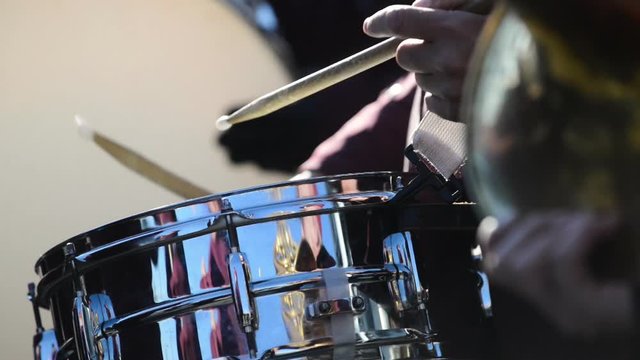 Detail footage depicting a drummer performing during a concert