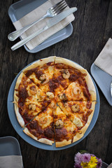 Pizza on wood table with dish top view