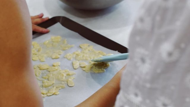 Young woman spreads out almond biscuit batter
