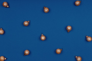Holiday season pattern with golden Christmas toys on classic blue, place for text