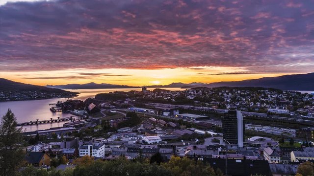 Narvik city scape fire sky vibrant sunset, thick clouds passing into the city time lapse in northern Norway