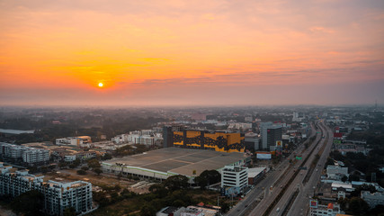Fototapeta na wymiar CHIANG MAI, THAILAND - DECEMBER 12, 2019 : Sunrise and office buildings of Chiang Mai in Thailand. Skyline view of cityscape with warm sunlight . Construction business concept..