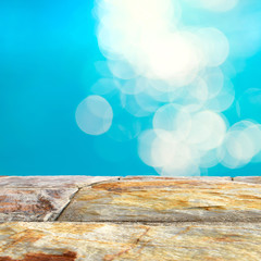 Brown stone table top and blurry blue water bokeh background