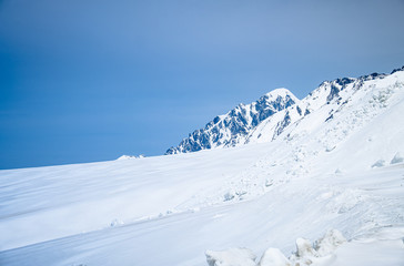 Fototapeta na wymiar close up top of white snow mountain view, snow covered beautiful landscape on blue sky background space.Famous place of snow mountains of Japan Alps in Tateyama Kurobe alpineat Toyama, Japan. 