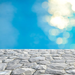 Gray stone top and blurry blue water bokeh background