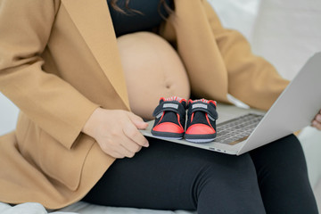 The pregnant woman is shopping online.