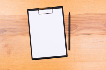 pen on blank white document sheet on wood clipboard on white wood table top view space
