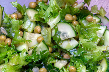 green salad with fresh cucumbers pea lettuce close up. Vegetarian vegetables salad.