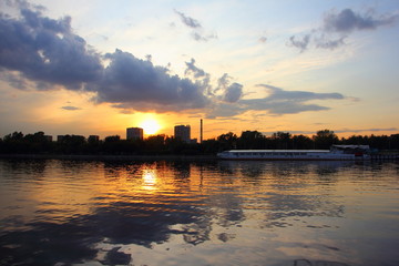 Fototapeta na wymiar Moscow River urban landscape on beautiful evening sunset and ship on water background