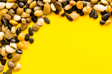 Sea stones background with yellow copy space top-down frame