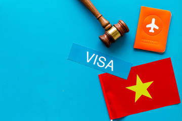 Visa to Vietnam concept. Vietnamese flag near passport and judge hammer on blue background top-down copy space