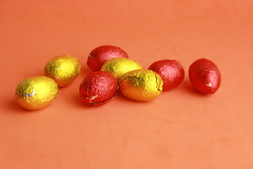 chocolate easter eggs, wrapped in yellow and red paper