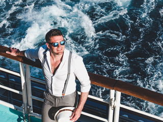 Smiling man on the empty deck of a cruise liner on the background of sea waves. Top view, close-up....