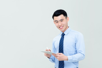 Young smiling Asian businessman using digital tablet with stylus pen i