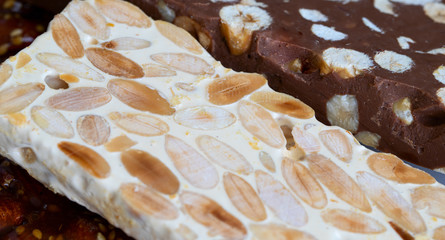 Close up of Turron duro or The nougat of Alicante with chocolate turron. Detail background