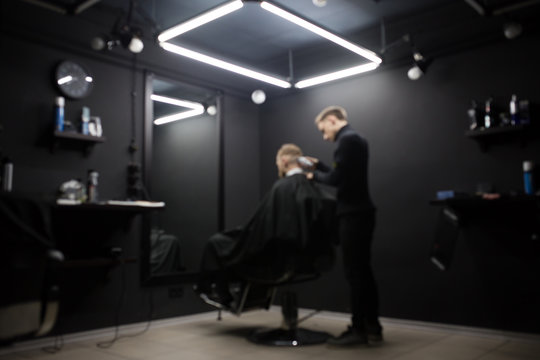 Blurred Photo Of A Barber Shop Room In Black Style And Lamps.