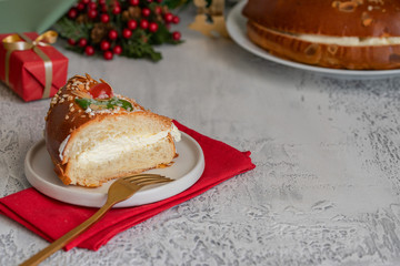 Roscon de reyes, traditional Spanish holiday dessert served the morning of Reyes, also known as Epiphany on January 6. Festive table setting with sweets and Christmas decoration.