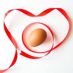 Healthy food with love valentine day idea concept, Isolated gift of fresh chicken egg with red heart ribbon sign symbol decorated on white table background-top view(selective egg soft focus)