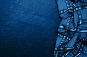 Checkered napkin on a concrete background toned classic blue color