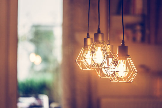 Lightning lamps at home, in restaurant or cafe: Close up of a hanging, orange lightbulbs