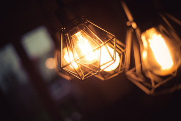 Lightning lamps at home, in restaurant or cafe: Close up of a hanging, orange lightbulbs