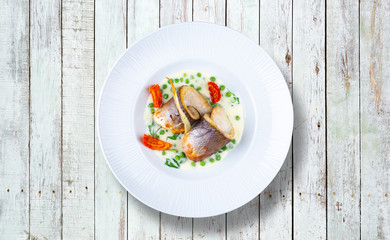 Sea bass fillet with mustard and baked tomatoes.