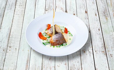 Sea bass fillet with mustard and baked tomatoes.