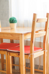 Details of a classic interior. Wooden dining area. Scandinavian style cuisine of the apartment in warm colors
