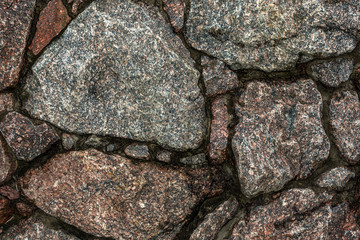 part of the wall of uneven stones natural granite with sharp edges