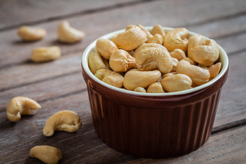 Cashew nut in brown bowl on wooden table