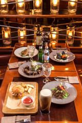 Gourmet meals assorted set on wooden table Buffet at restaurant with light bulbs