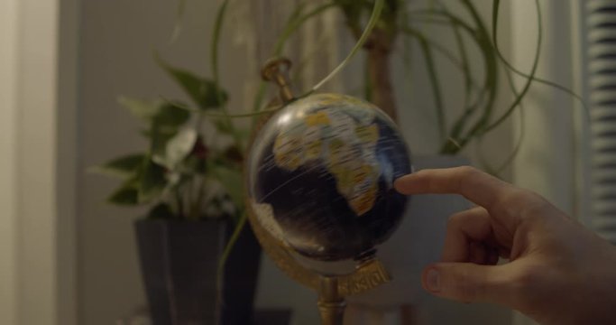 Globe spins. Finger lands on Australia. Full 4K slow motion.